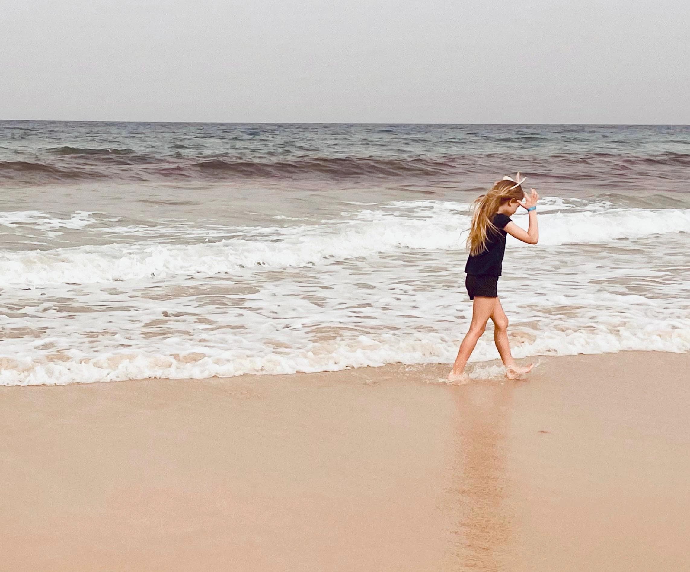 Una bambina che cammina sulla spiaggia